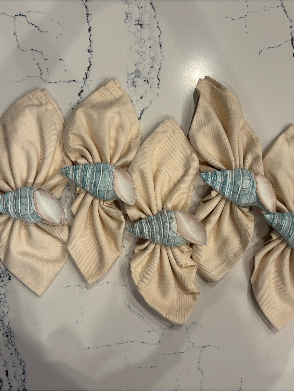 Blue-Turquoise Shell Napkin Rings with cream napkins